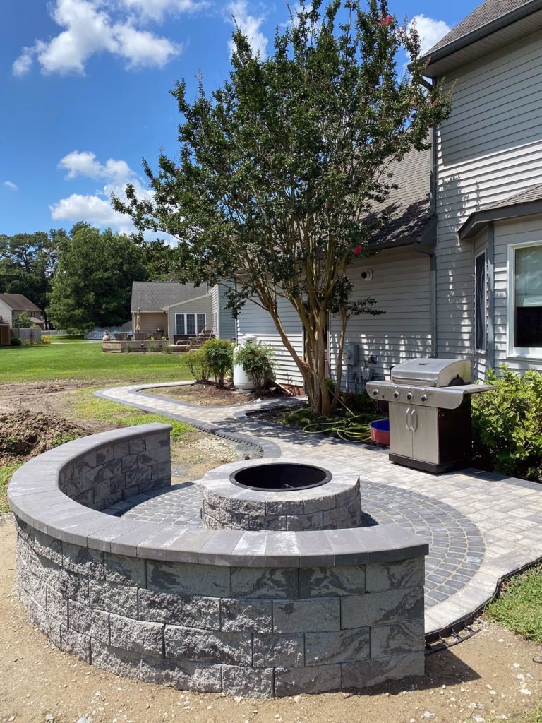 stone firepit and walkway leading to back of house