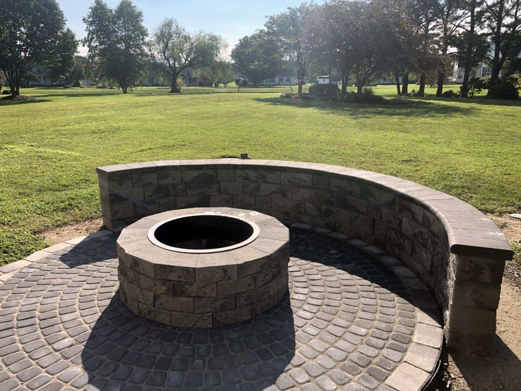 backyard stone firepit with circular base and stone bench