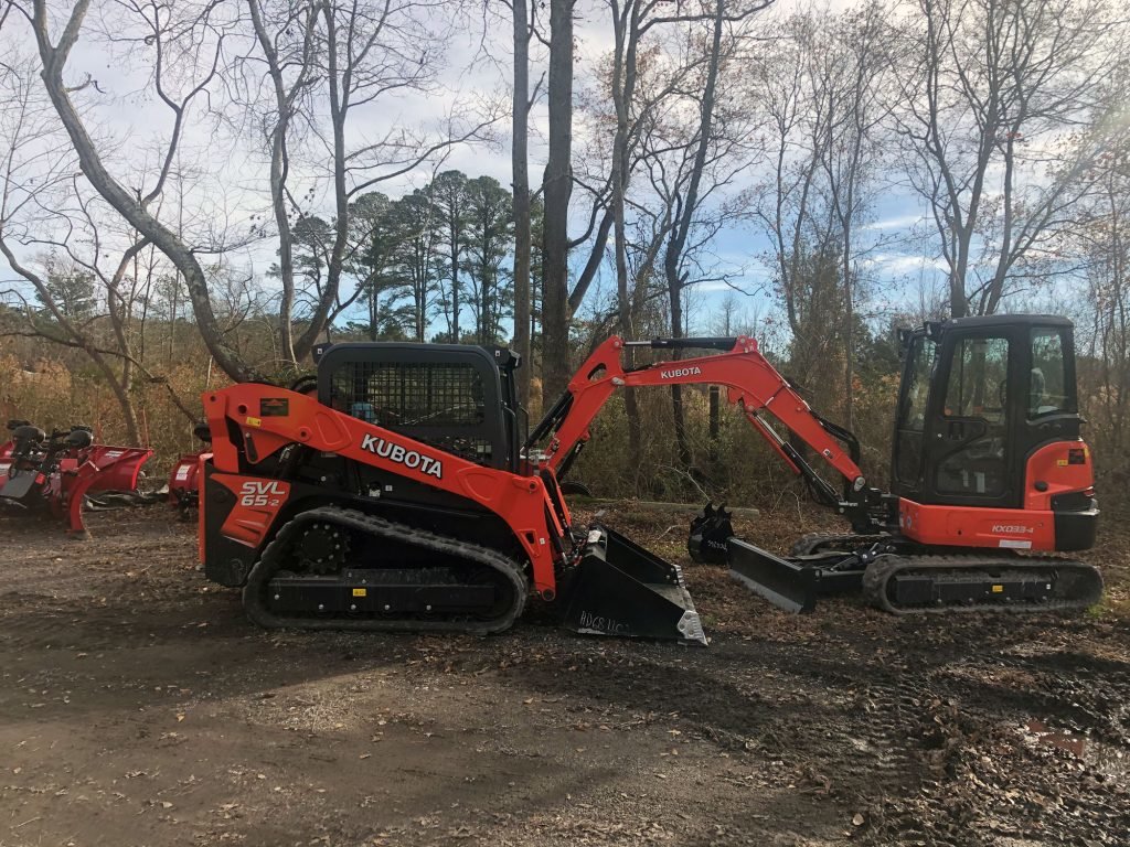 2 excavators in backyard surrounded by woods