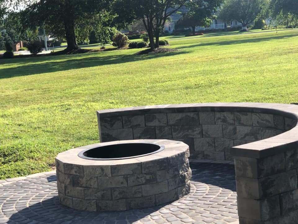 backyard stone firepit with circular base and half circle stone bench